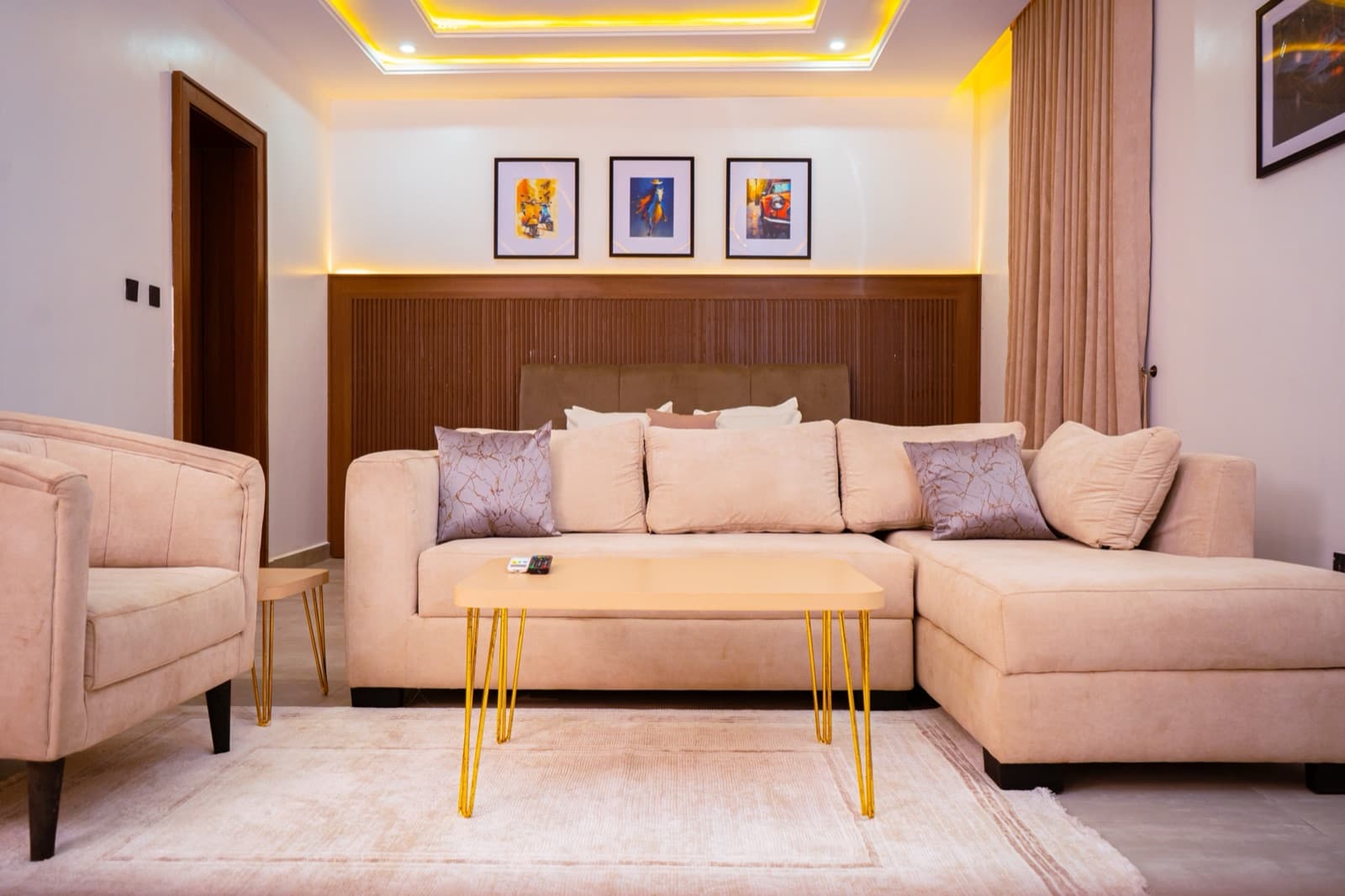 Lounge with a cream sectional sofa, gold coffee table and framed art