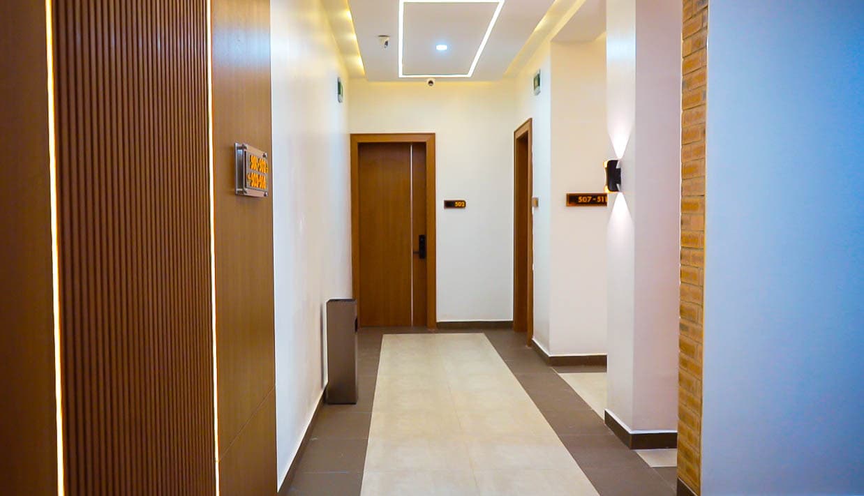 Corridor with wood-panelled walls and lit ceiling strips