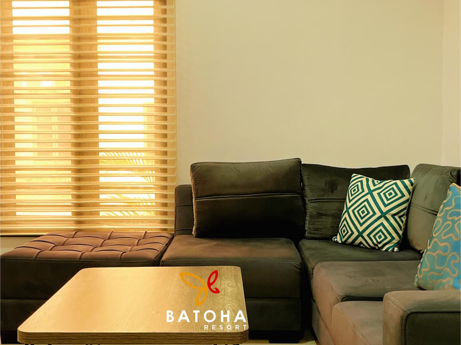 Close-up of a grey sofa with patterned cushions beside a coffee table