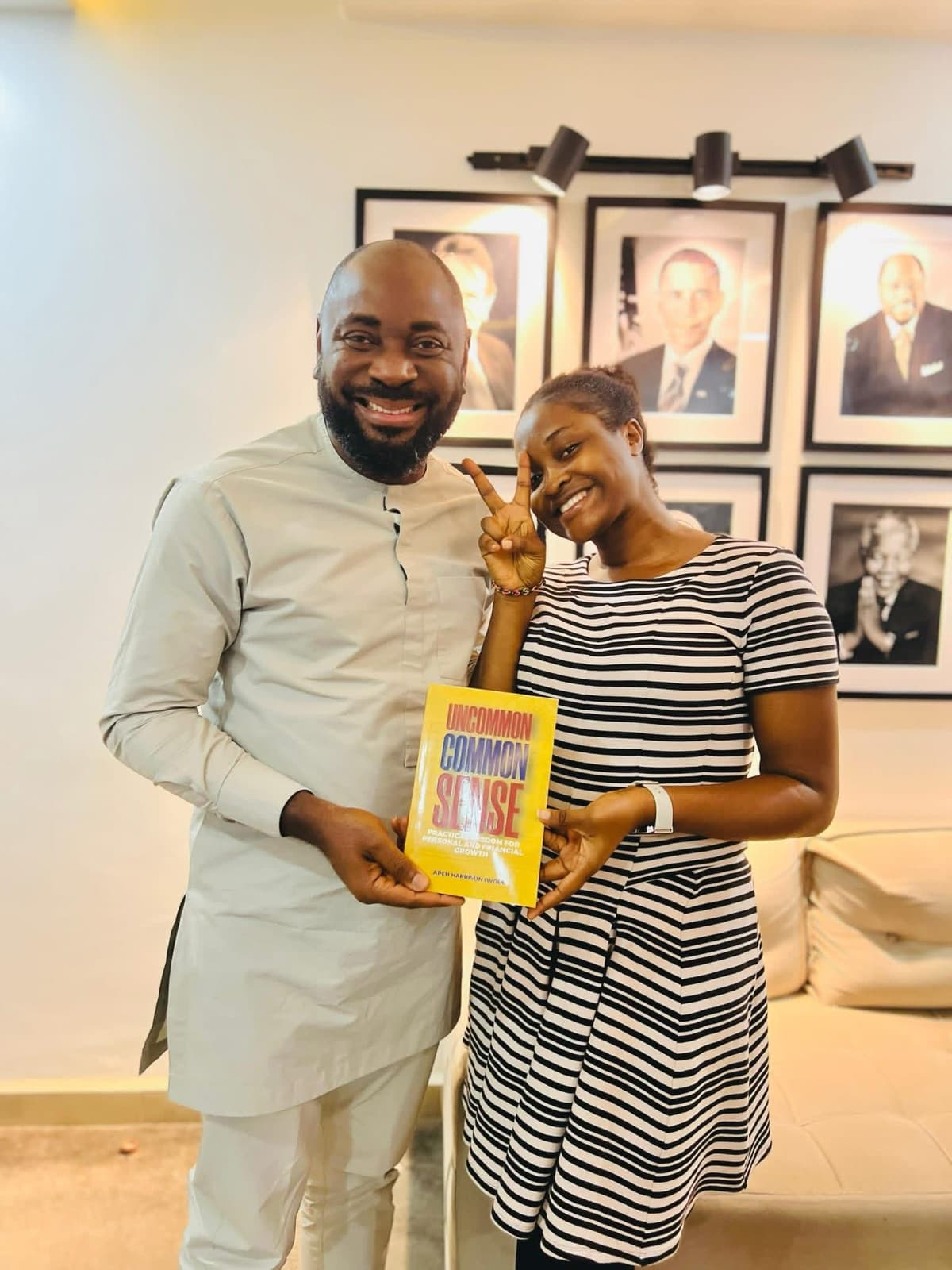 A man and a young woman smiling together, holding a copy of Uncommon Common Sense