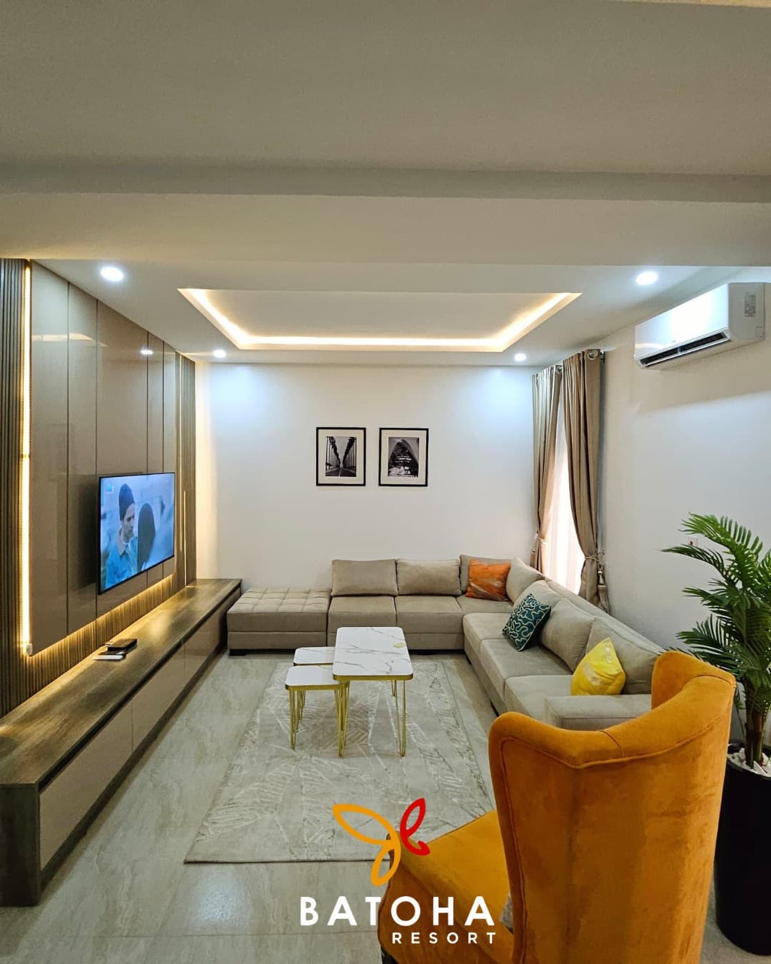 Living area with an orange velvet armchair and a recessed ceiling