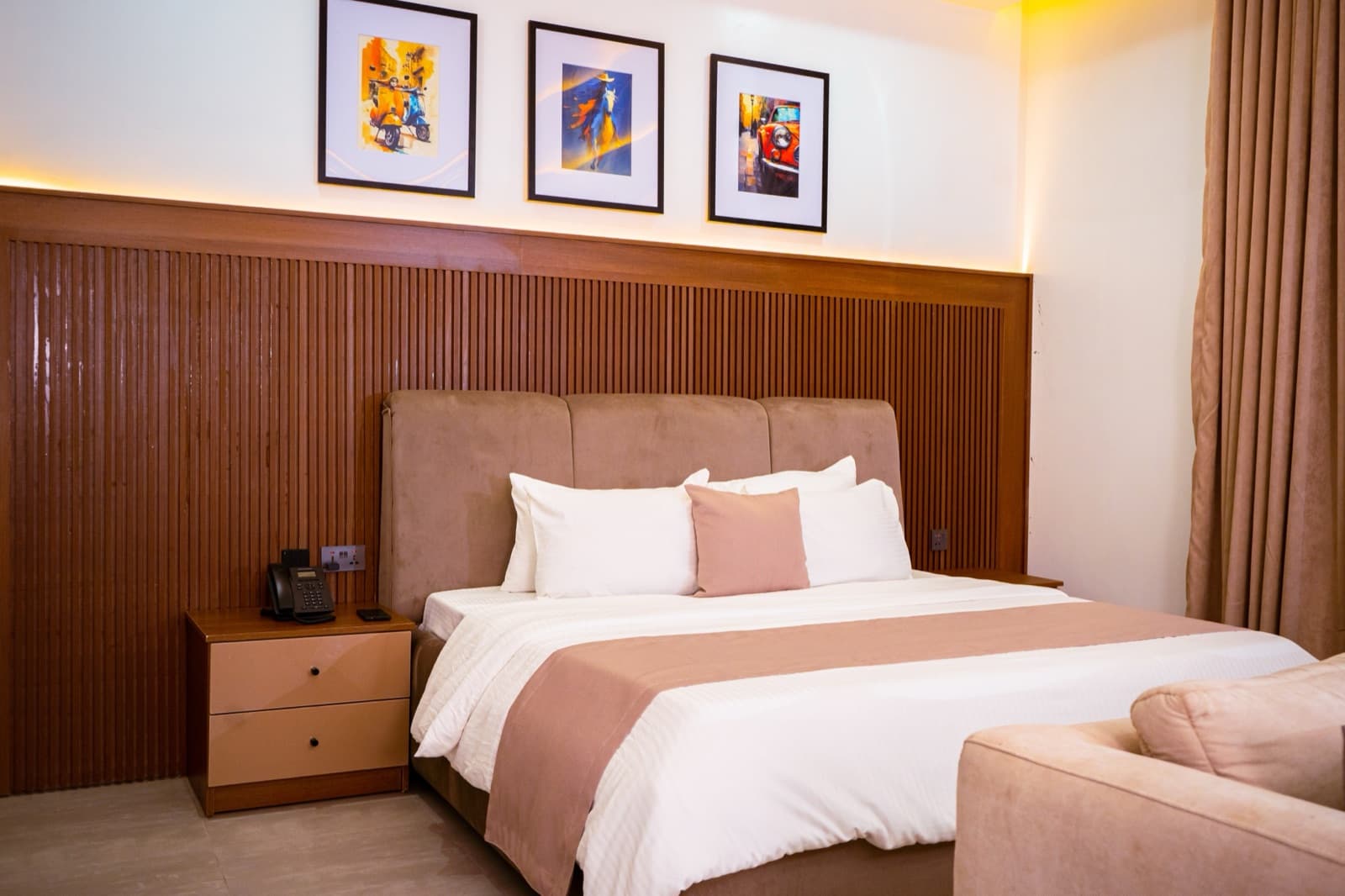 Bed with a slatted wooden headboard and three framed prints