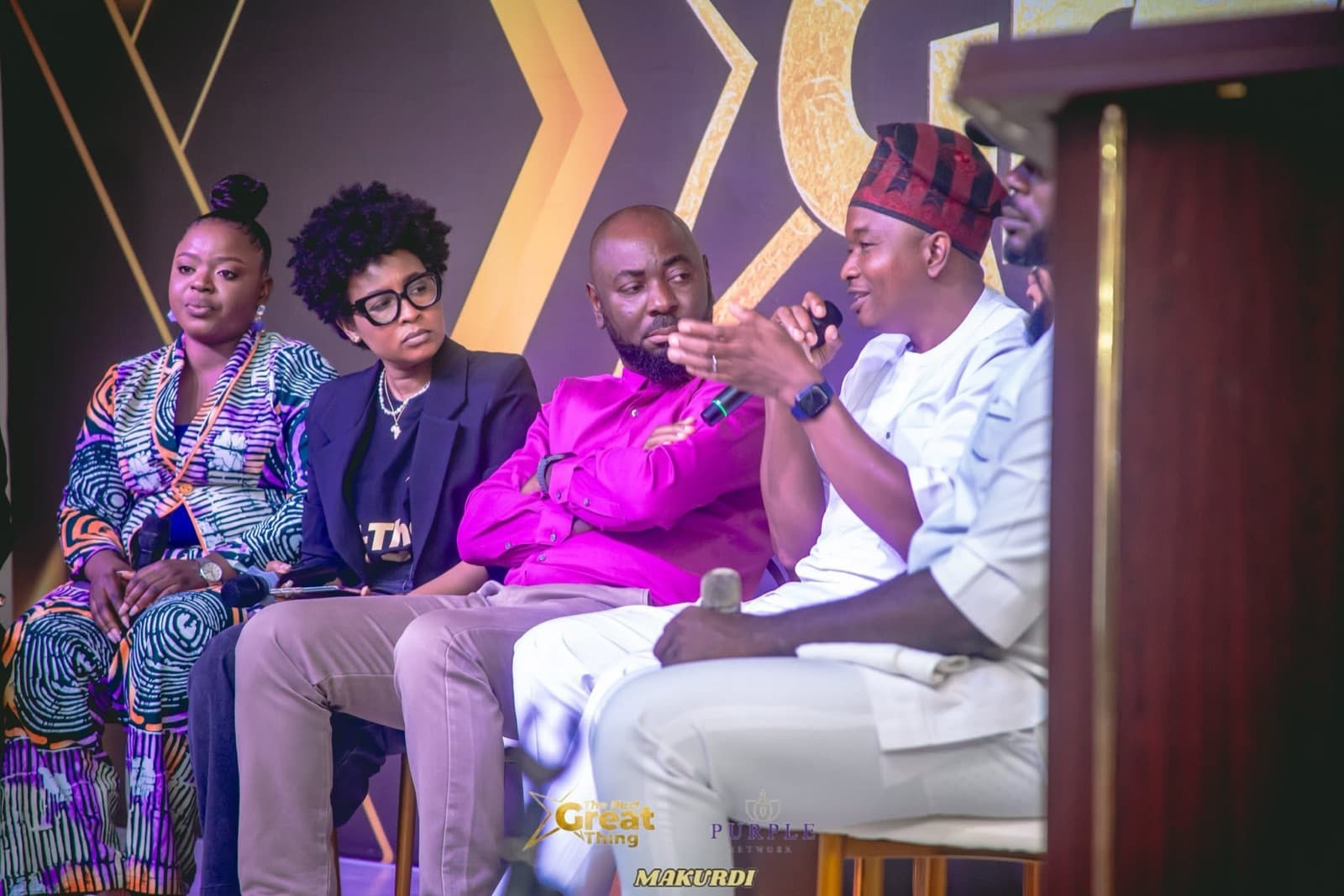 Panel of speakers seated on stage during a discussion