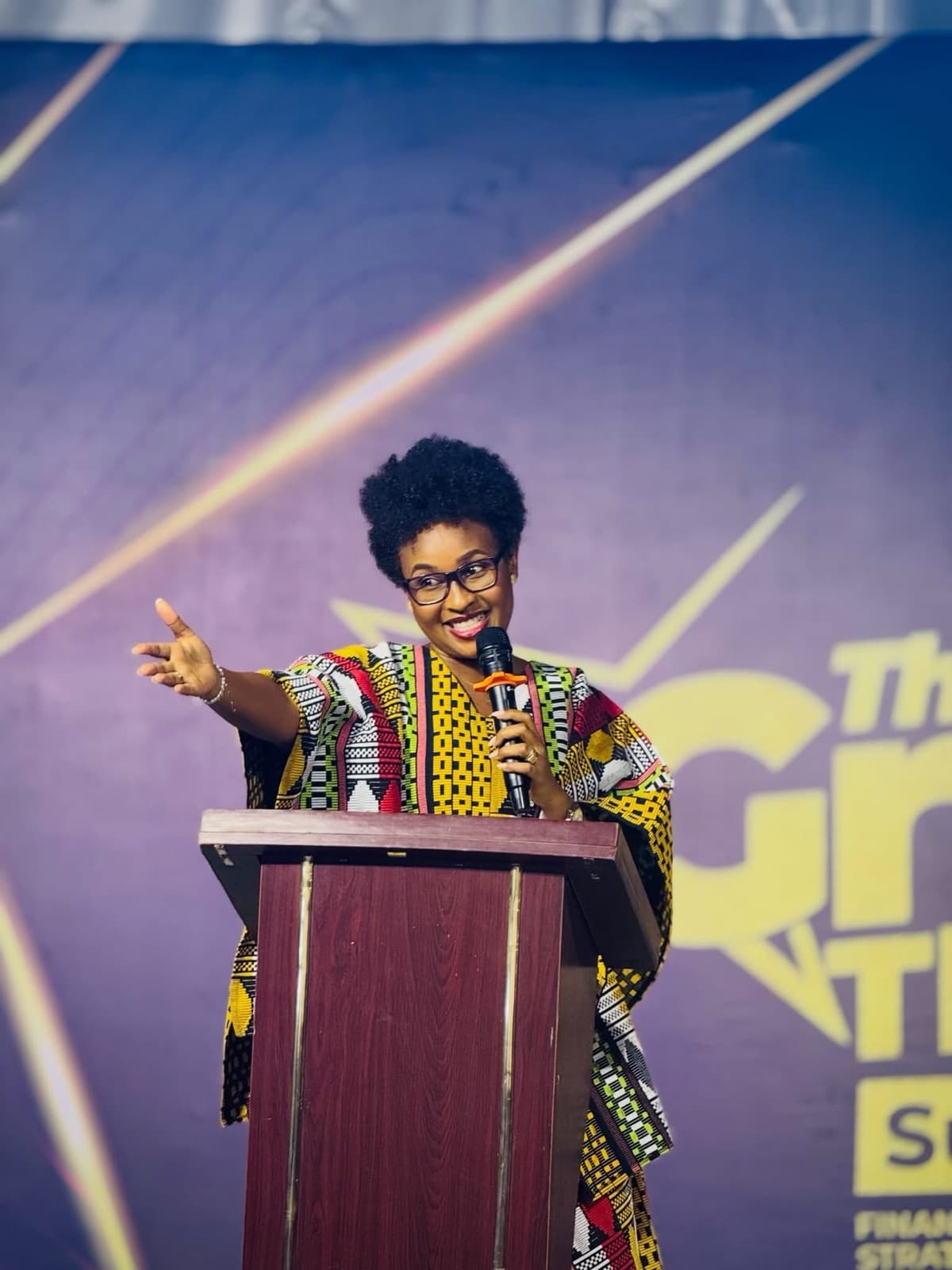 Speaker in an African-print outfit at a podium