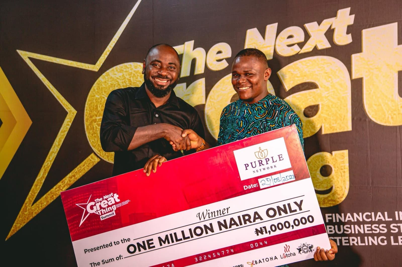 Two people shaking hands behind a one million naira prize cheque