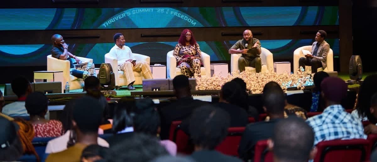 Panel of speakers seated on stage in front of an audience