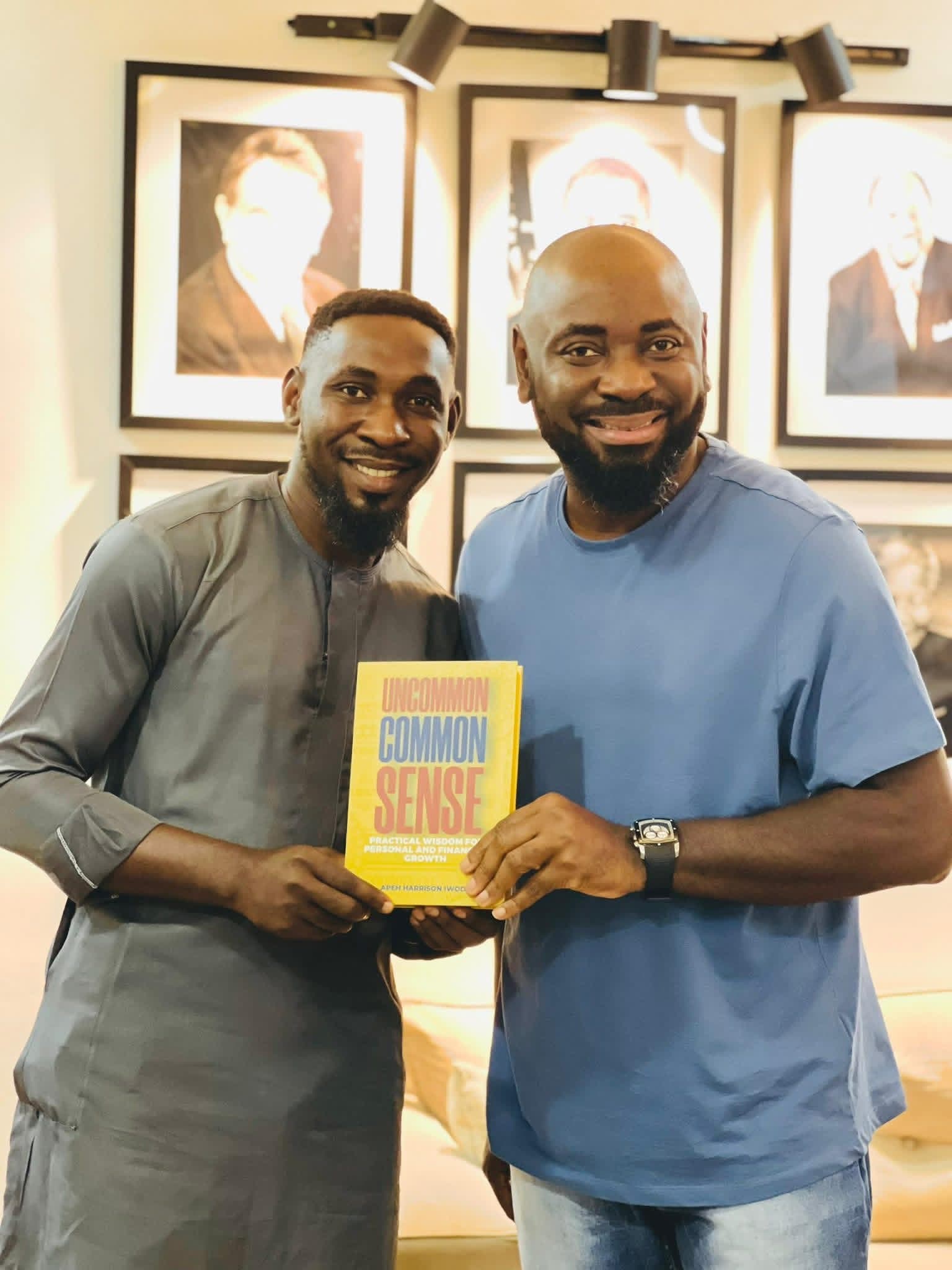 Two men smiling and holding a copy of Uncommon Common Sense